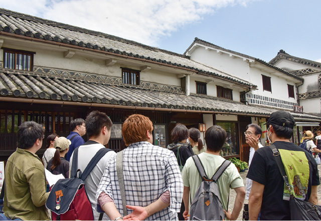 写真：古民家再生論の様子。再生された古民家にて講師から話を聞く学生たち。